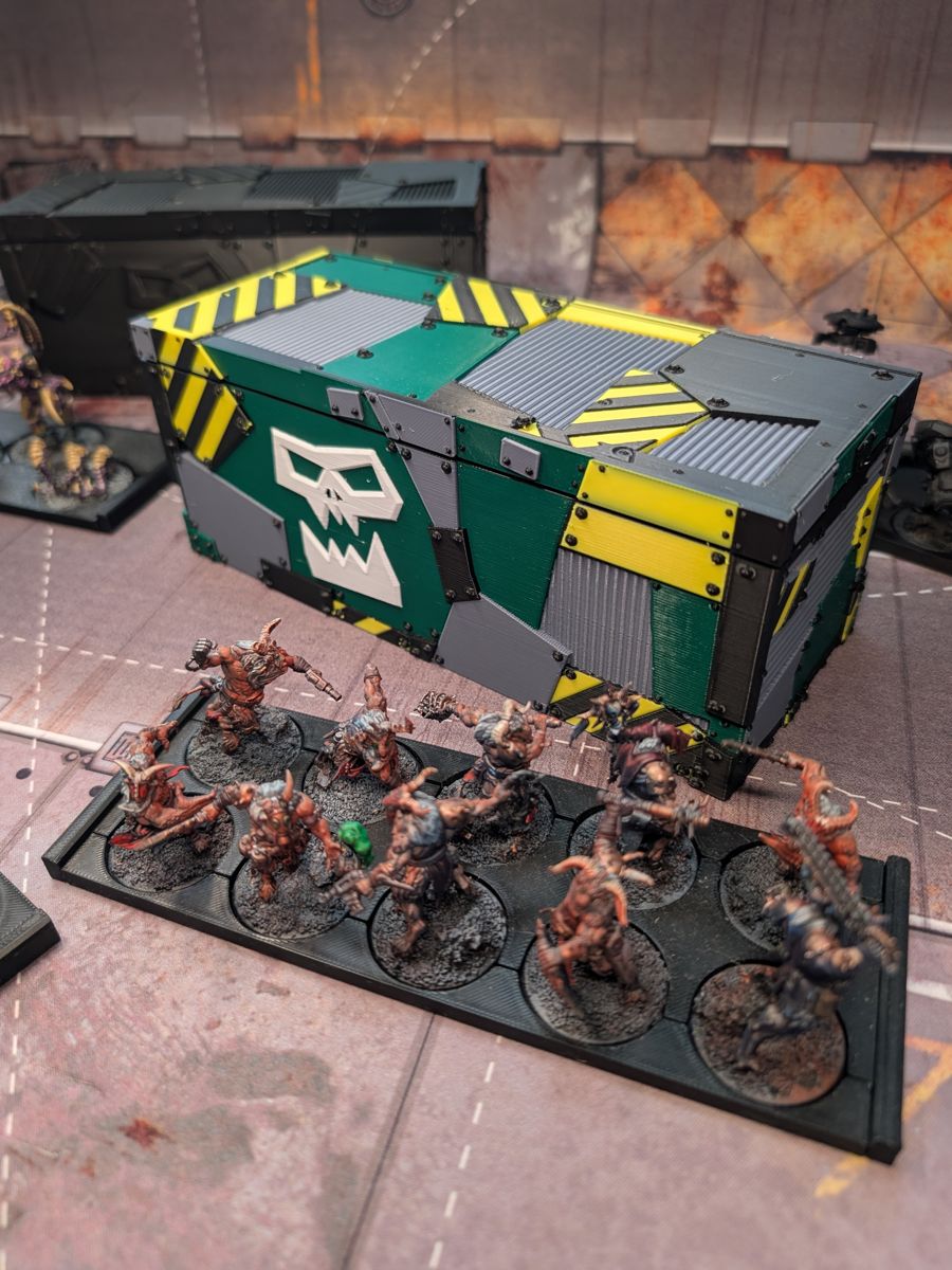 A tray of painted miniatures in front of the closed case